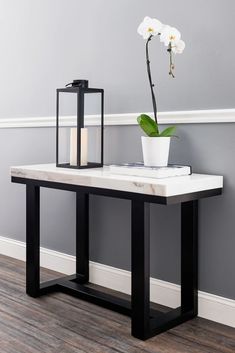 a white flower sitting on top of a table next to a vase with a candle