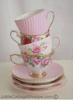 a stack of cups and saucers with pink flowers on them