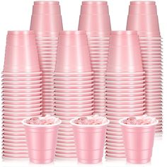 pink cups are stacked on top of each other in rows, with the lids slightly down