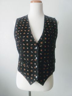 "90s black and rose paisley and floral print button up vest by Byer California. Made in USA. Size small. Black buttons and faux pockets. Elastic at back waist. Excellent condition - see fourth photo for minor imperfection at back sleeve seam.  Measurements (taken lying flat, doubled for circumference): 36\" at buttons 22\" sleeve circumference 22\" long from shoulders to angled hemline" Fitted Floral Print Sleeveless Vest, Fitted Casual Vest With Buttons, Fitted Sleeveless Paisley Print Top, Casual Cotton Vest With Floral Print, Fitted Cotton Vest With Button Closure, Vintage Black Vest For Spring, Black Vintage Vest For Spring, Vintage Vest With Button Closure For Spring, Fitted Cotton Vest With Floral Print