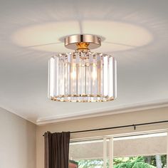 a living room filled with furniture and a chandelier hanging from the ceiling over a window