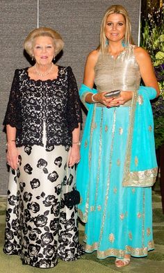 two women standing next to each other in dresses