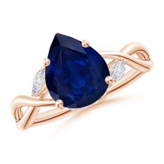 an oval blue sapphire and diamond ring with two pear shaped diamonds on the band, set in