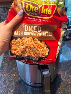 someone holding up a bag of diced hash browns in front of an instant pot roaster