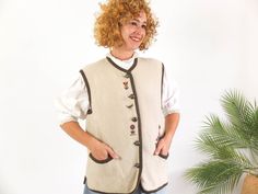 Amazing vintage 90's Austrian dirndl vest in beige and brown with floral embroidery. This vintage folk embroidered trachten vest has large metal button up and pockets. The 90's Alpine Tyrolean Bavarian vest is boiled Wool fabric in excellent vintage conditions (Made in Austria). The sweater vest is size Medium or Large, the chest contour fit is 40,1 inches (102 cm) ** MEASURES FLAT ** Armpit to armpit 20 in // 51  cm Shoulder 16,5 in // 42 cm Length from shoulder 24,8 in // 63 cm Length from armpit 14,5 in // 37 cm Reference: Model size S (4 US - height 65 in) Reference: Dummy size M (6 - 8 US) **We take great care in describing the garment with all the details and exact measurements for your verification, so you can secure the purchase.  Remember to read the store policies to know the rul Winter Floral Embroidered Sleeveless Vest, Fitted Floral Embroidered Vest For Fall, Vintage Beige Winter Vest, Wool Vest Women, Folk Vest, Chest Contour, Boiled Wool Fabric, 90s Floral, Vest Women