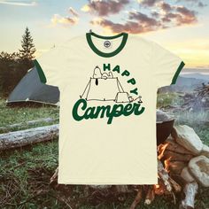 Start Camping Season off right with the perfect t-shirt! Our Happy Camper Tee comes in White and Green Ringer Tee to add the perfect funny touch to your next trip! *THE PICTURE MAKES THE TEE LOOK NATURAL/BEIGE COLORED BUT THE TEE IS WHITE WITH GREEN. LISTING IMAGE SHOULD BE UPDATED SHORTLY.* Adult Unisex Tee with 'Happy Camper' and Snoopy Tent image on the front. Available in sizes S-3X in White and Green Ringer Tee! If you want a different color option, message me and we can work something out! Funny Letter Print T-shirt For Outdoor, Green Graphic Print T-shirt For Camping, Summer Camping T-shirt With Crew Neck, Cotton T-shirt With Funny Print For Outdoor Activities, Pre-shrunk Green T-shirt For Camping, Funny Print T-shirt For Outdoor Activities, Green Letter Print T-shirt For Outdoor Activities, Green T-shirt With Letter Print For Outdoor Activities, Green T-shirt With Letter Print For Outdoors