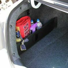 the trunk compartment of a car with bottles and other items in it's cargo area