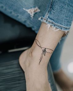 a woman's foot with a small tattoo on the left side of her ankle