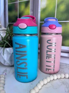 two water bottles sitting next to each other on a counter