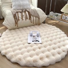 a living room with a large round rug on the floor next to a white couch