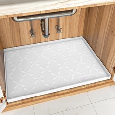 a close up of a kitchen sink with a mat on the bottom and under it