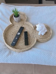 a mickey mouse tray with remote control and air plant on it, sitting on a bed