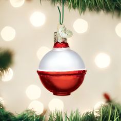 a red and white ornament hanging from a christmas tree