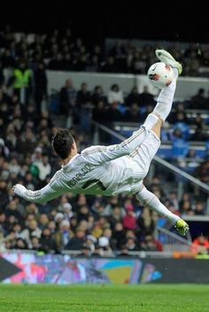 a soccer player is in mid air after kicking the ball