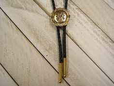 Complete your look with this Western Southwestern Concho Polished Brass Bolo Tie. The Unisex, Unique Design will make you Standout everywhere.. -  Perfect gift for Her, Him, Yourself,...Valentines Day, Christmas, Birthday, Anniversary, and more -  Affordably Priced and always in style -  Southwestern Native American Inspired Concho Bolo Tie,  -  *Medium Sized Pendant*, -  Hand Polished Brass with an Antiqued Finish, -  Anti-Tarnish added for longer Lasting Beauty,  - 30 TO 42 inch, Genuine Black Adjustable Gold Western Bolo Ties, Western Style Gold Lariat Jewelry, Gold Western Bolo Tie, Adjustable Gold Concho Jewelry, Adjustable Western Gold Jewelry, Adjustable Gold Western Jewelry, Adjustable Southwestern Gold Jewelry, Bohemian Gold Jewelry With Concho, Gold Bohemian Jewelry With Concho