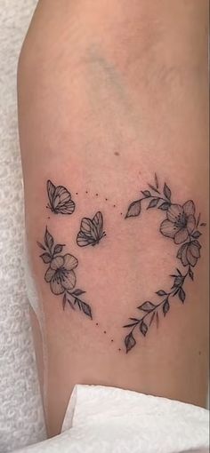 a heart shaped tattoo with flowers on it