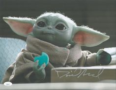 the child yoda is sitting at a table