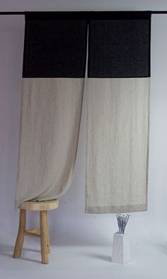 two black and white curtains are hanging over a stool