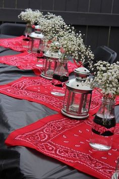 there are many vases with flowers in them sitting on the table cloth that is laid out