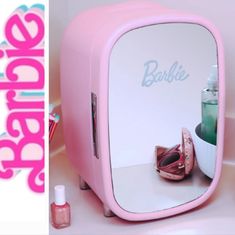 a pink vanity mirror sitting on top of a counter next to a cup and bottle