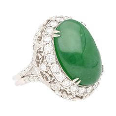 "Indulge in the elegance and allure of this 24.04 carat Jade and Diamond Halo cocktail ring, expertly crafted in 18K White Gold. Elevate your jewelry collection with this captivating piece that combines the beauty of Jade with the brilliance of diamonds. Make a statement of luxury and style with this resizable ring, destined to become a cherished heirloom for generations to come. Item Details: - Type: Ring  - Metal: 18K White Gold  - Weight: 14.39 grams  - Style: Art Noveau  - Setting: Prong  - Diamond Halo Ring, Pattern Ring, Halo Diamond Ring, Natural Jade, Ring Metal, Halo Rings, Diamond Halo, Oval Cabochon, Style Art