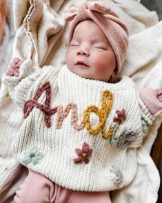 Personalized Embroidered Name Sweater Kids -- Hand Embroidered Sweater  These hand embroidered name sweaters are just what you need for your littles! Sizes 0-6m to 3T (3T is large and can fit up to a 6 year old!) The sweaters listed tend to be oversized. Please size down one size if you would like it more fitted.  100% Organic Cotton NOTE: the Camel sweaters are not as oversized, and are more of a fitted sweater.  PLEASE NOTE: If you do not leave your yarn color choice in the customizable box wi Baby Name Sweater Knit, White Long Sleeve Sweater With Floral Applique, Cute Cotton Sweater With Floral Embroidery, Knit Name Sweater, Name Sweater Baby, Embroidered Name Sweater, Hand Embroidered Sweater, Hand Embroidered Name, Embroidered Onesie