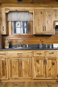 a kitchen with wooden cabinets and black counter tops