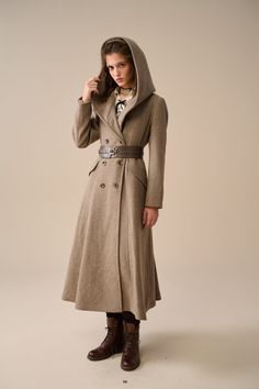 A style you'll cherish for years to come, this coat is the perfect blend of sophistication and comfort. The wool fabric used in our coat is carefully selected to provide maximum comfort and durability. and the intricate weave creates visual and tactile interest that sets this coat apart from the rest. The double-breasted closure and loose fit create a timeless and relaxed silhouette that adds a touch of sophistication to your outfits. the large hood adds an extra layer of warmth, perfect for those chilly mornings, and the pockets add a practical touch so you can keep your essentials close at hand. Immerse yourself in a palette of rich and timeless colors - classic classic gray, warm camel, vibrant red, versatile oat cream - to suit every taste and occasion. Whether you prefer understated e Elegant Hooded Wool Outerwear, Elegant Long Sweater Coat For Winter, Elegant Long Gray Wool Coat, Elegant Hooded Wool Coat For Winter, Elegant Hooded Winter Outerwear, Elegant Hooded Pea Coat For Work, Winter Coat Elegant, Modern Medieval, Plus Size Coat