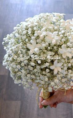 a person holding a bouquet of white flowers