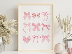 pink bows are displayed on a white wall next to vases