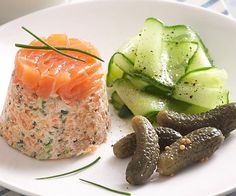 a white plate topped with cucumbers and salmon