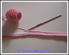 a pink ball of yarn next to a pair of scissors