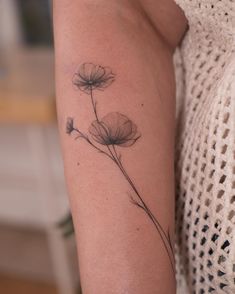 a woman's arm with a flower tattoo on it