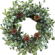 a green wreath with pine cones and berries