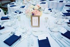 the table is set with blue napkins, silverware, and flowers on it