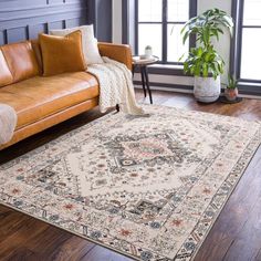 a living room area with a couch, chair and rug