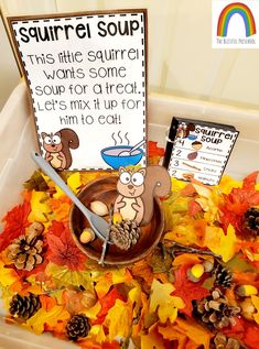 a bowl filled with lots of autumn leaves next to a sign that says squirrel soup