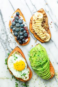 three slices of toast with avocado, blueberries and an egg on top