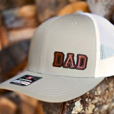 Custom Richardson 112 Trucker style snapback hats make great gifts for new dads, new grandfathers, birthdays, Valentine's Day, Father's Day and of course, Christmas! Our genuine leather patches are laser engraved and laser cut to your custom specifications and applied to Richardson 112 Trucker style caps. You choose the personalization and the color of the cap you would like. Richardson 112 Adjustable Snapback Trucker Cap: - 60/40 cotton/polyester - 100% polyester mesh back - Structured, six-pan Adjustable Curved Brim Hat For Father's Day, Letter Print Hat For Father's Day Gift, Adjustable Flat Bill Dad Hat For Father's Day, Father's Day Hats With Letter Print, Father's Day Gift Hats With Letter Print, Personalized Flat Bill Hats For Outdoors, Personalized Flat Bill Hats For Outdoor, Curved Brim Baseball Cap For Father's Day, White Adjustable Baseball Cap For Father's Day