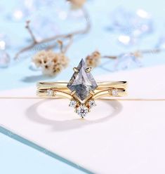 a diamond ring sitting on top of a piece of paper with flowers in the background