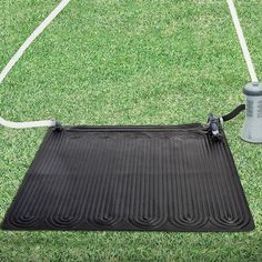 a black mat on the grass with a sprayer attached to it