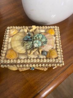 there is a decorative box on the table with seashells and shells in it