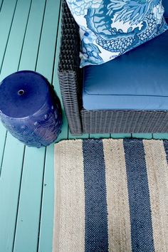 a blue and white rug sitting on top of a wooden floor next to a chair