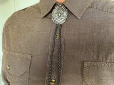 This awesome bolo tie handmade has a southwestern silver design. The cord is genuine black leather. Our bolos pair nicely with many of our belt buckles! They make wonderful gifts. The western bolo tie rope length is 40''. We can customize lengths and cord color, please ask! Tie Outfits Men, Bolo Tie Men, Necklace Leather Cord, Western Bolo Tie, Mens Leather Necklace, Tie Necklace, Bolo Ties, Necklace Leather, Mens Necklace