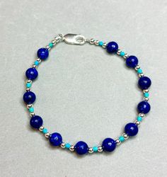 7 inches. Blue Lapis lazuli with turquoise and sterling silver filled beads and clasp. Spiritual Blue Adjustable Sterling Silver Bracelet, Handmade Adjustable Blue Sterling Silver Bracelet, Adjustable Blue Sterling Silver Bracelet With Silver Beads, Sterling Silver Beaded Bracelets With Silver Clasp, Blue Beaded Sterling Silver Bracelet, Handmade Blue Sterling Silver Beaded Bracelets, Sterling Silver Jewelry With Polished Blue Beads, Turquoise Polished Beads Bracelet In Sterling Silver, Blue Lapis Lazuli Bracelets With Polished Beads