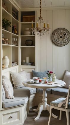 a table with two chairs and a bench in front of a bookcase filled with books