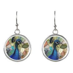 a pair of earrings with an image of a peacock on the front and back of it