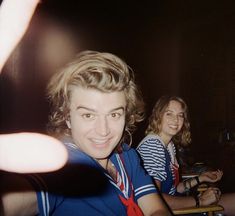 two people sitting at a table with drinks in front of them