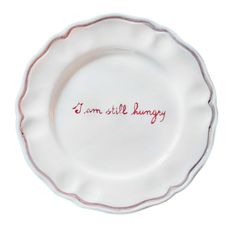 a white plate with red writing that says i am still hungry on the front and bottom