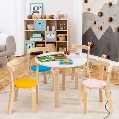 children's table and chairs in a playroom with bookshelves on the wall